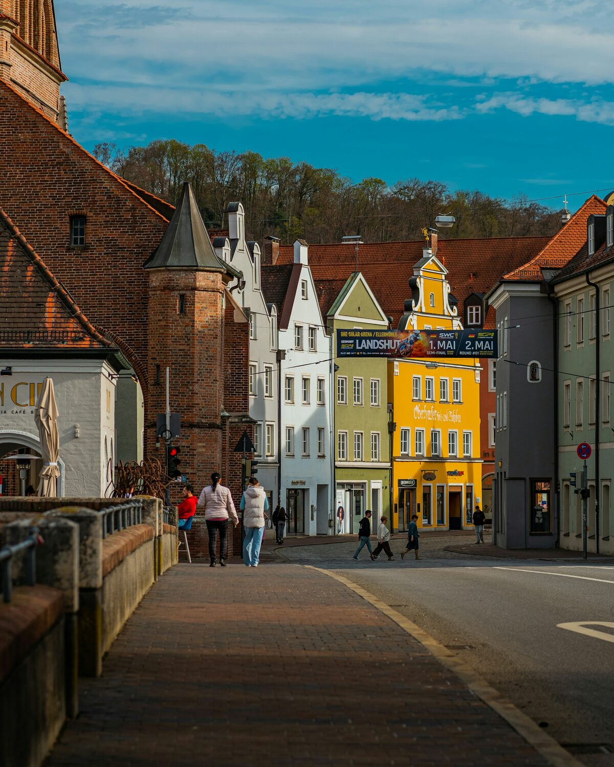 Farbige Bürgerhäuser mit Treppengiebeln in der Landshuter Altstadt, links der Backstein der Heilig-Geist-Kirche