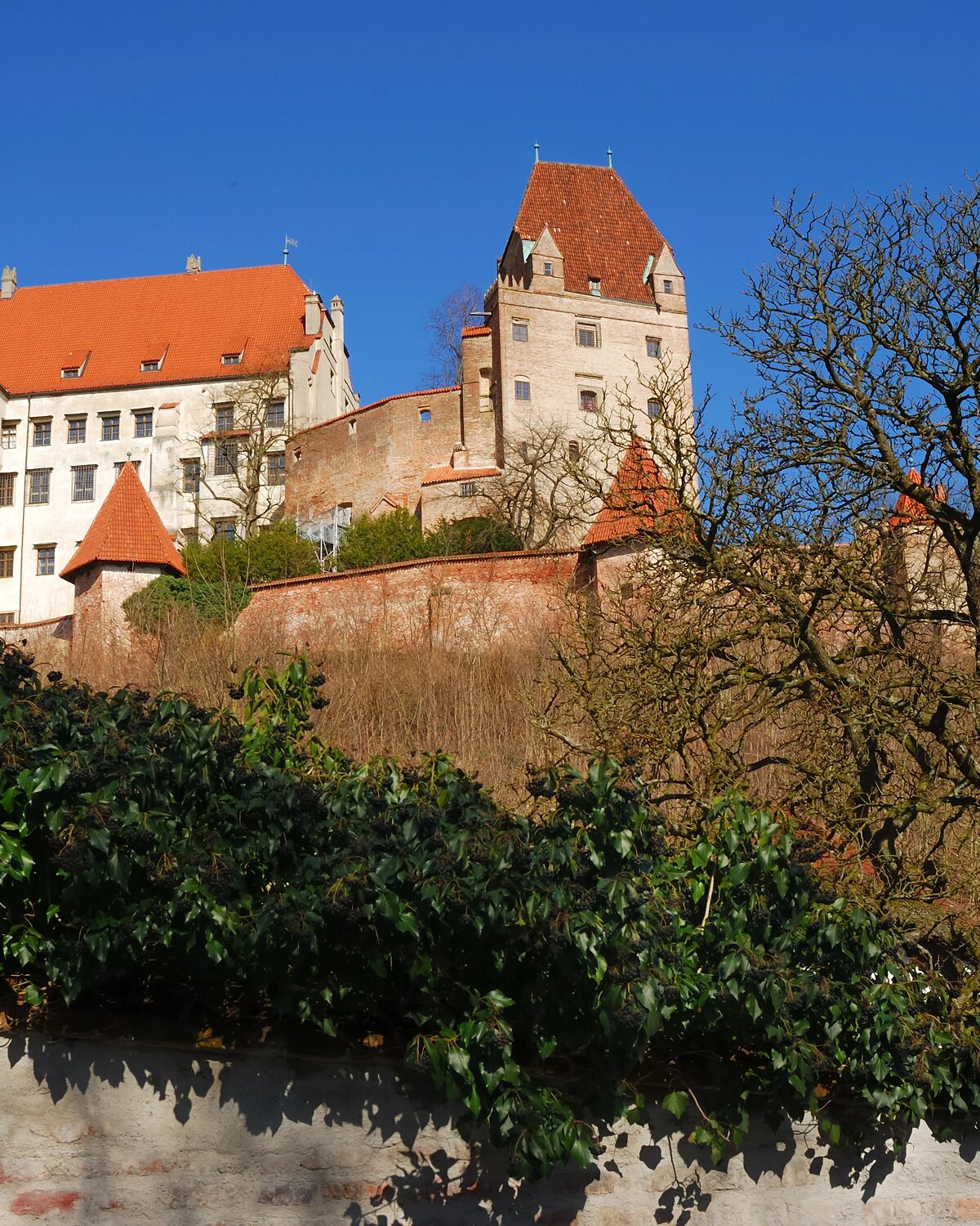Die Burg Trausnitz oberhalb von Landshut mit Wehrmauer und rotem Ziegeldach