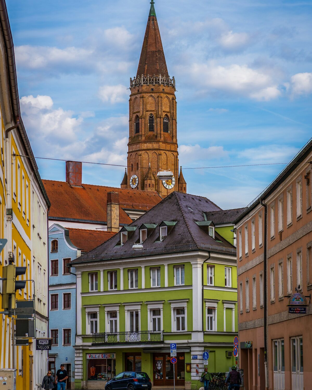 Der Backsteinturm von St. Jodok mit achteckigem Aufsatz und Spitzhelm über den Dächern von Landshut