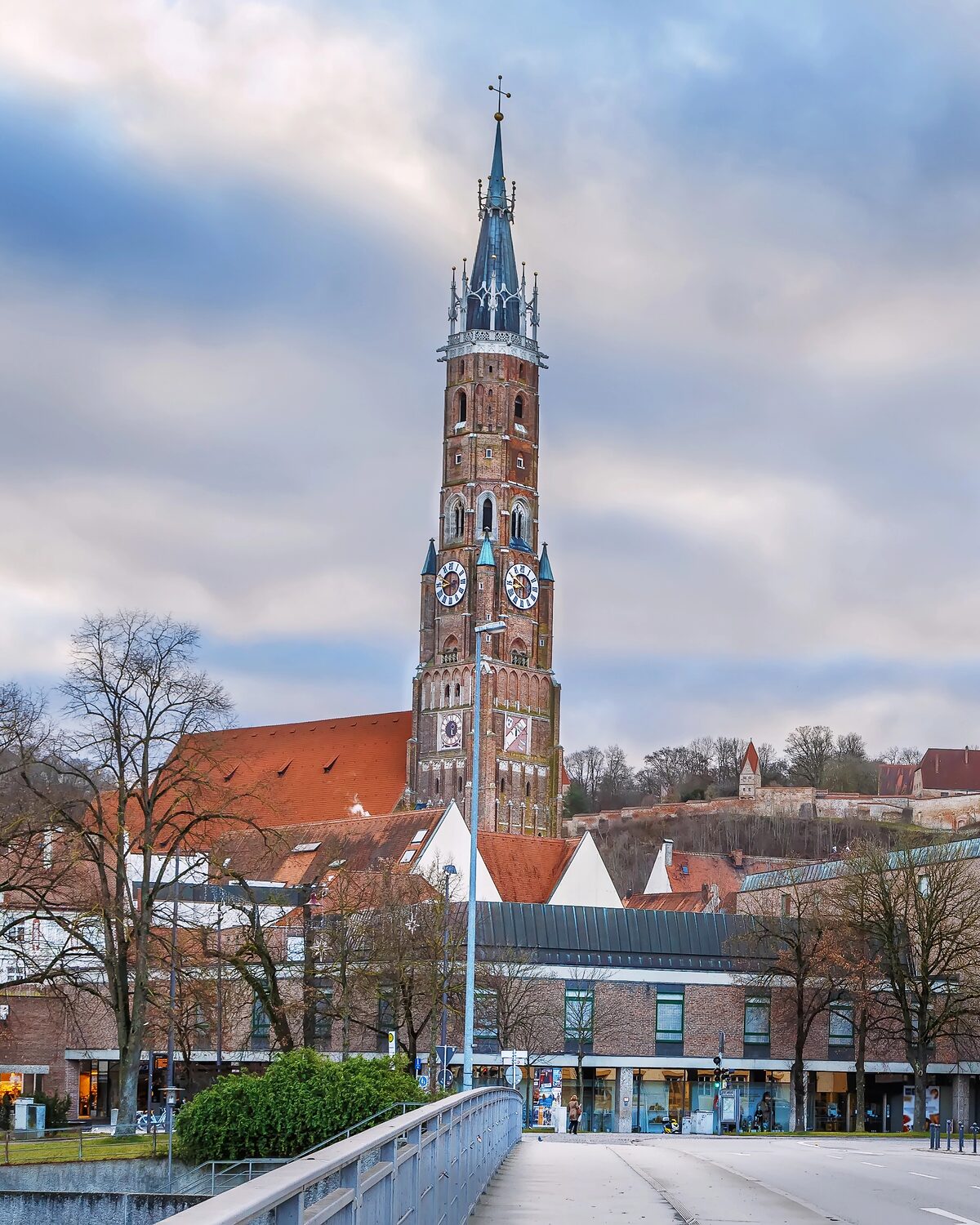 Der Backsteinturm der Stiftsbasilika St. Martin in Landshut in voller Höhe mit Turmuhr und Spitzhelm