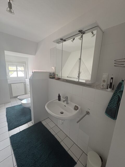 Zweites Bad mit Waschbecken, Spiegelschrank und WC unter der Dachschräge